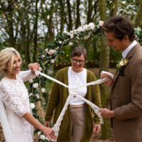 Handfasting is a lovely way to symbolise the joining of two lives to become one Celebrant handfasting a wedding couple at an outdoor ceremony
