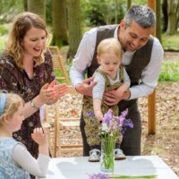 A flower ceremony signifies togetherness and support. Celebrant led naming ceremony in woodland wedding venue